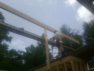 Carpenter setting a ridge beam over a new addition frame — Ice Dam Removal by Roofing Brothers in Nathrop