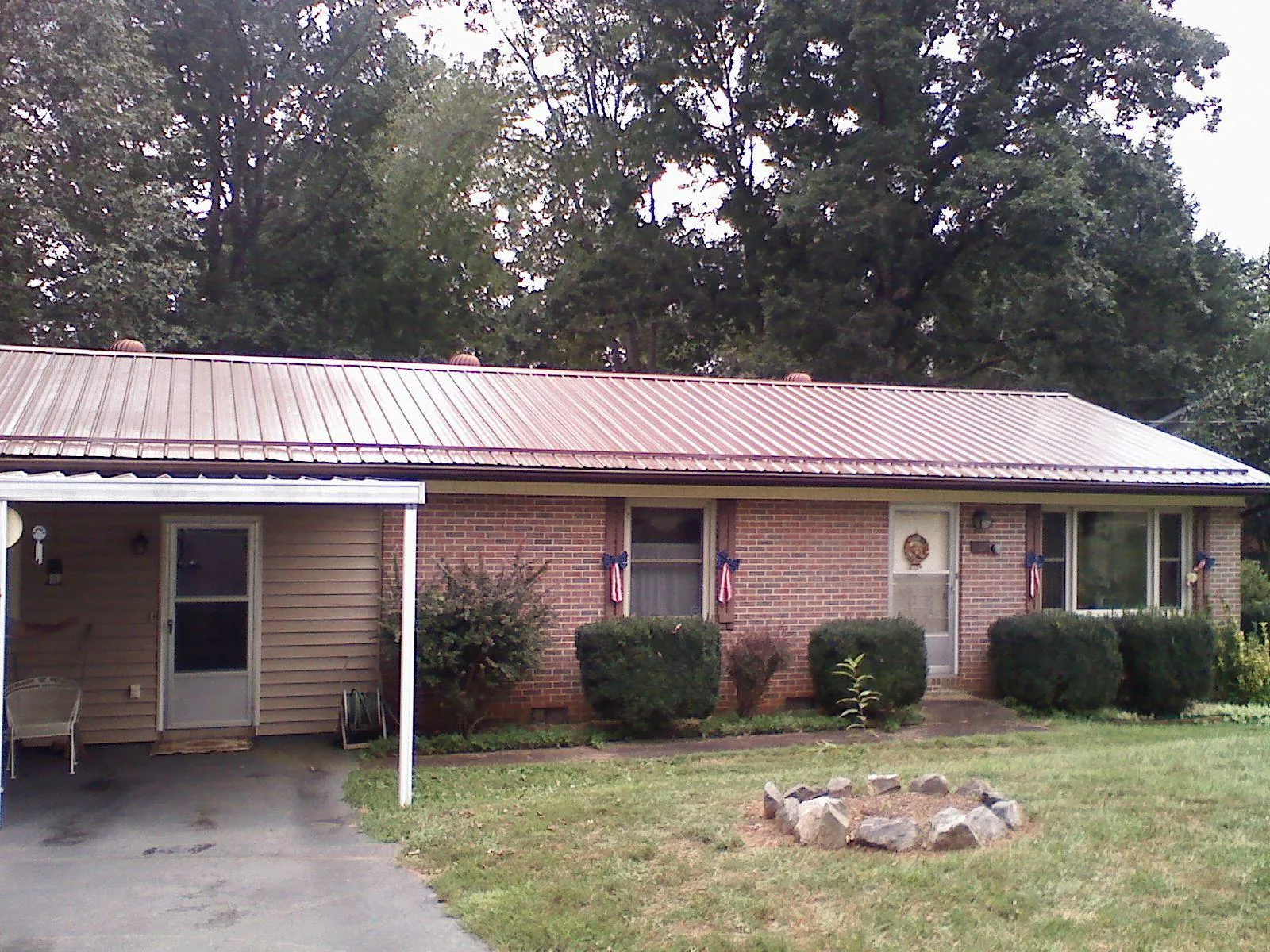 Bronze metal roof and carport on a brick ranch home — Roof Repair work by our crew in Nathrop